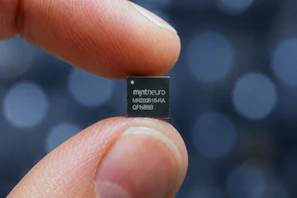 MintNeuro microchip held between fingertips displaying model number MN200816-RA