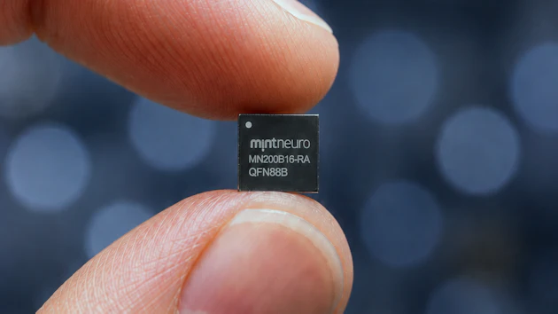 MintNeuro microchip held between fingertips displaying model number MN200816-RA