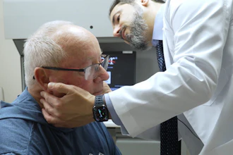 Doctor performing neck examination on elderly patient in clinical setting