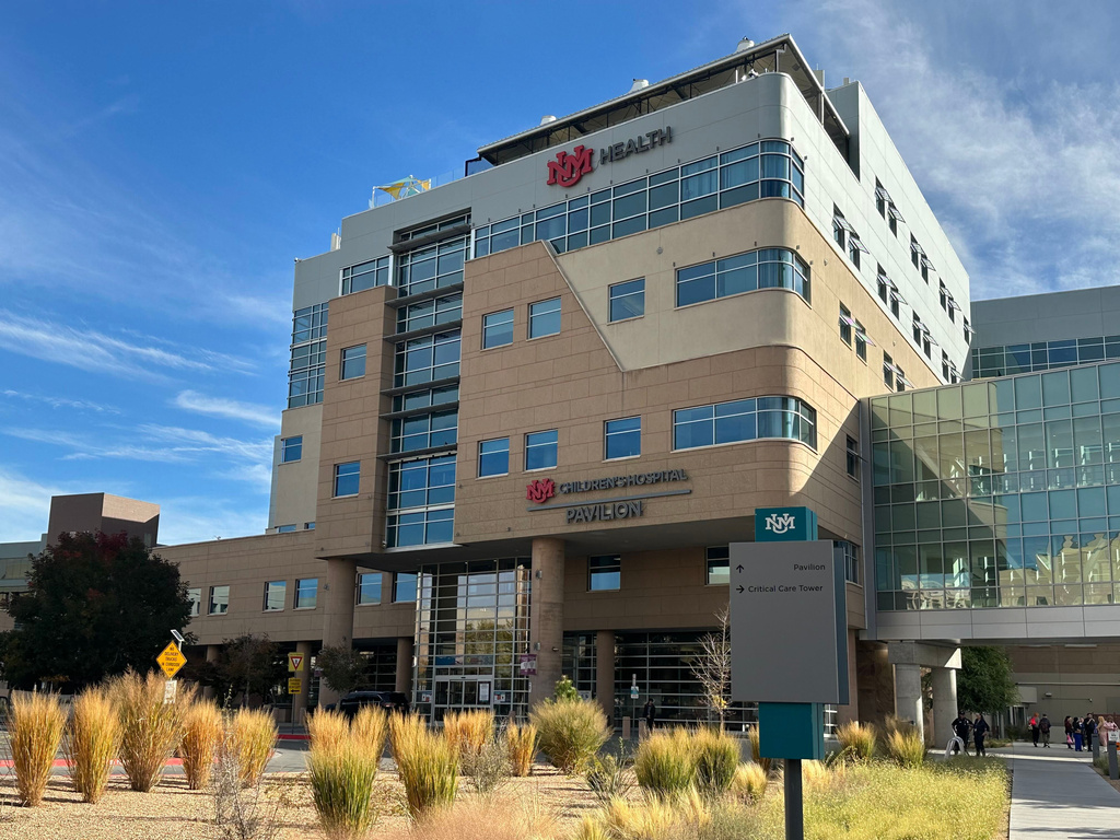 IHC Health multi-story medical facility building with modern architecture, glass windows, and desert landscaping under blue sky