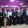 Eight business professionals posing at a Vantive Mountain Home corporate event with purple branded backdrop