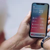 Person holding smartphone displaying daily health metrics including steps, activity, sleep tracking, and meditation data with date June 25