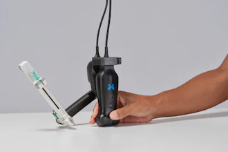 Person holding black handheld gimbal stabilizer with blue X logo and attached smartphone mount