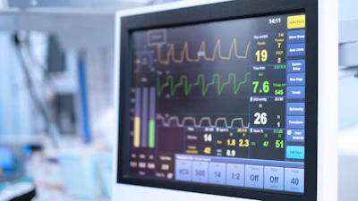 Hospital patient monitor displaying vital signs including heart rate, oxygen saturation, and waveform tracings in clinical setting