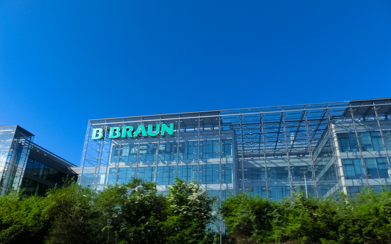B. Braun corporate headquarters building with green illuminated signage on modern glass facade