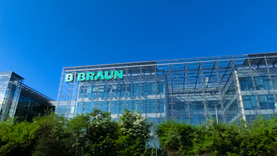 B. Braun corporate headquarters building with green illuminated signage on modern glass facade