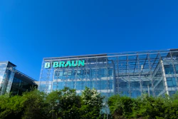 B. Braun corporate headquarters building with green illuminated signage on modern glass facade