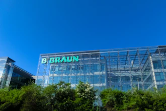 B. Braun corporate headquarters building with green illuminated signage on modern glass facade