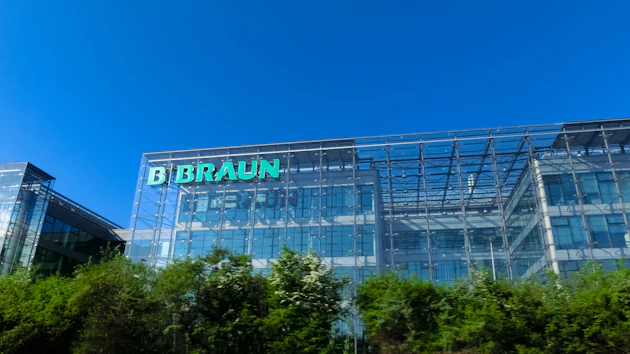 B. Braun corporate headquarters building with green illuminated signage on modern glass facade