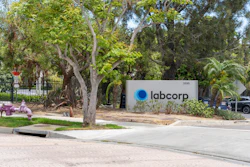 Labcorp corporate sign at building entrance with mature trees and landscaping