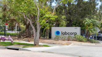 Labcorp corporate sign at building entrance with mature trees and landscaping
