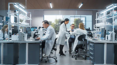 Scientists and technicians working in a modern laboratory with microscopes and analytical equipment