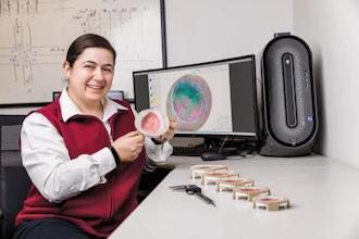 Scientist holding petri dish with bacterial culture at laboratory workstation with analysis software displayed on monitors