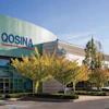 OOSINA corporate building exterior with teal and white facade, autumn foliage, and clear blue sky